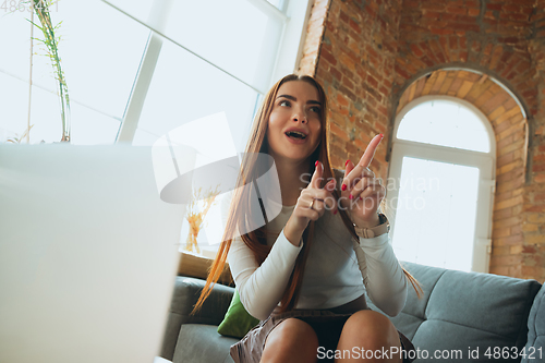 Image of Caucasian woman singing during online concert at home isolated and quarantined, impressive improvising, dancing