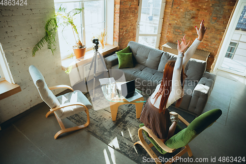 Image of Caucasian woman singing during online concert at home isolated and quarantined, impressive improvising, dancing