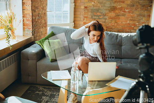 Image of Caucasian woman singing during online concert at home isolated and quarantined, impressive improvising, dancing