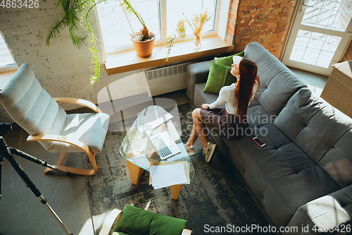 Image of Caucasian woman singing during online concert at home isolated and quarantined, impressive improvising, dancing