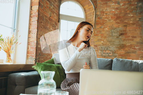 Image of Caucasian woman singing during online concert at home isolated and quarantined, impressive improvising