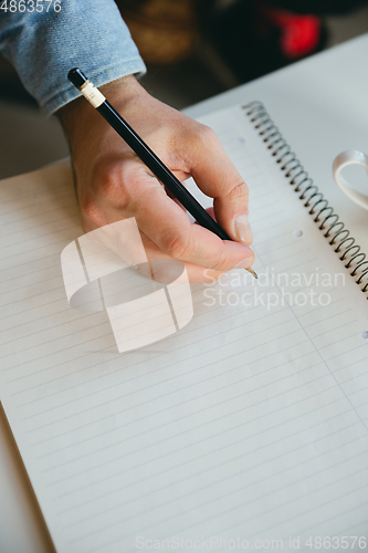 Image of Caucasian musician making notes during online sound-check or concert with the band