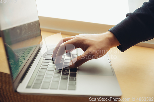 Image of Close-up of male fingers typing a business document, note or search key on the laptop