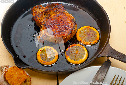Image of pork chop seared on iron skillet