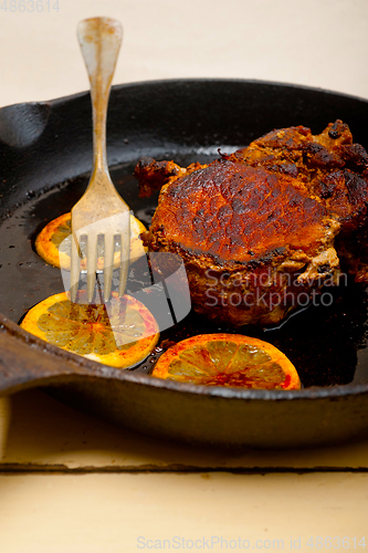 Image of pork chop seared on iron skillet