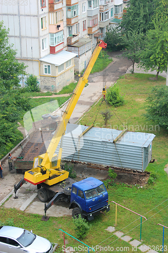 Image of truck with hoisting crane loading the wagon