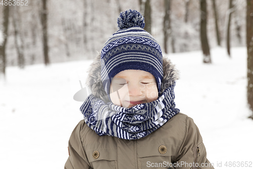 Image of Child in winter, portrait squint blink