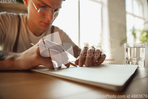 Image of Close up of male hands writing on an empty paper, education and business concept