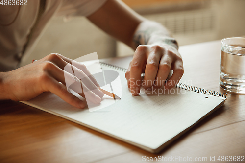 Image of Close up of male hands writing on an empty paper, education and business concept