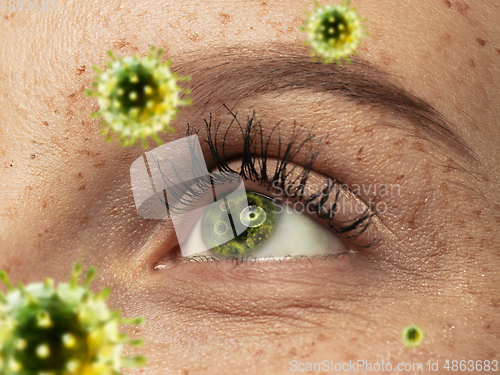 Image of Close up shoot of a female eye with 3D-illustrated coronavirus models, the way of infecting