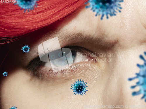 Image of Close up shoot of a female eye with 3D-illustrated coronavirus models, the way of infecting