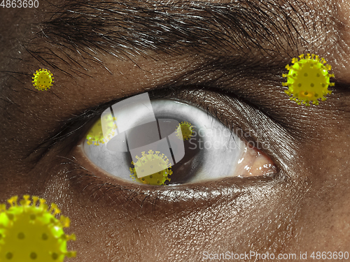 Image of Close up shoot of a male eye with 3D-illustrated coronavirus models, the way of infecting