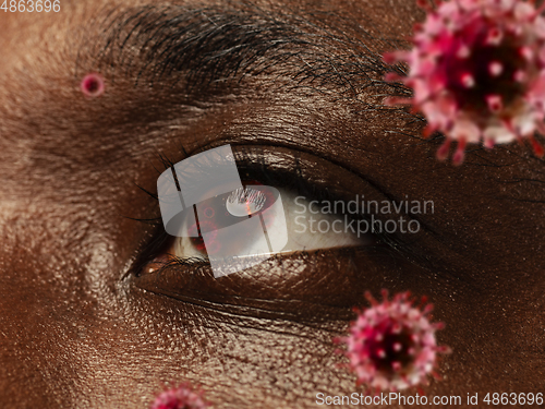 Image of Close up shoot of a male eye with 3D-illustrated coronavirus models, the way of infecting