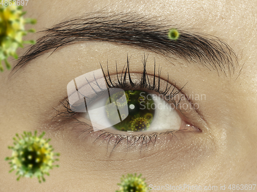 Image of Close up shoot of a female eye with 3D-illustrated coronavirus models, the way of infecting