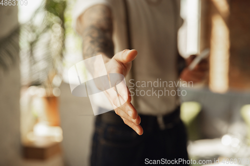 Image of Close up of male hand greeting, welcoming somebody