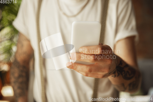 Image of Close up of male hands using smartphone, education and business concept