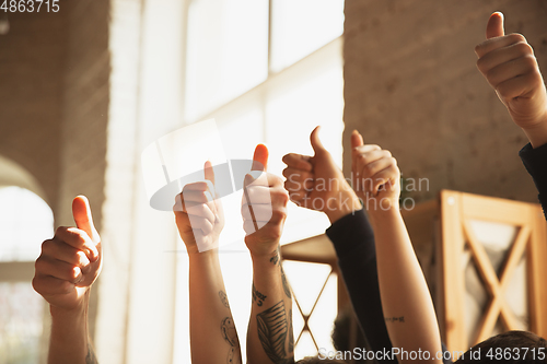 Image of Close up of caucasian male and female hands showing nice, thumbs up