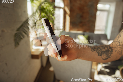 Image of Close up of male hands using smartphone, education and business concept