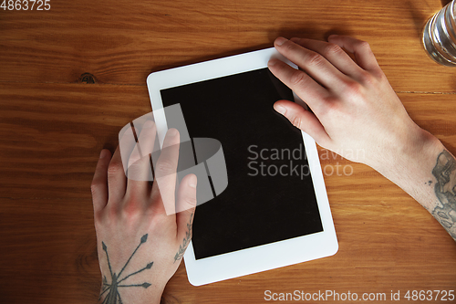 Image of Close up of male hands using tablet with blank screen, copyspace, education and business concept, top view