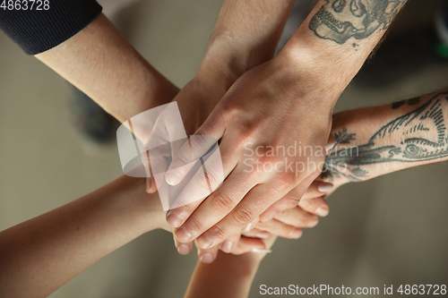 Image of Close up of caucasian male and female hands, covering one another, team, friendship, business
