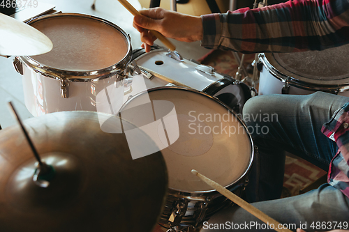 Image of Caucasian musician playing drumms during online concert with the band at home isolated and quarantined, inspired improvising, close up