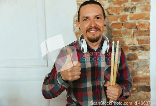 Image of Caucasian musician greeting audience during concert at home isolated and quarantined, smiling, cheerful