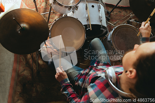 Image of Caucasian musician playing drumms during online concert with the band at home isolated and quarantined, inspired improvising, close up