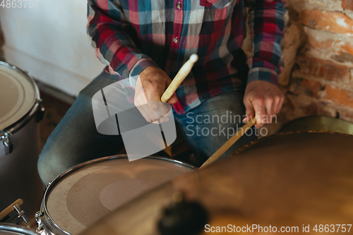 Image of Caucasian musician playing drumms during online concert with the band at home isolated and quarantined, inspired improvising, close up