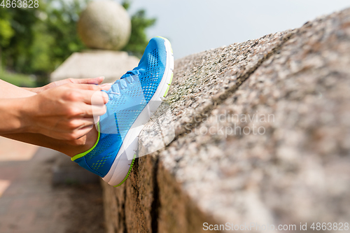 Image of Woman tying laces for jogging 