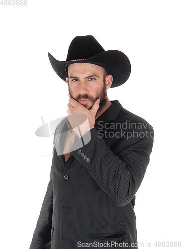 Image of Man in gray jacket and cowboy hat, hand on face