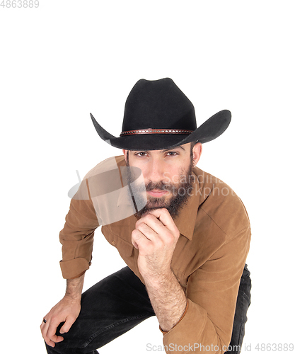 Image of Handsome man in brown shirt, his hand on face