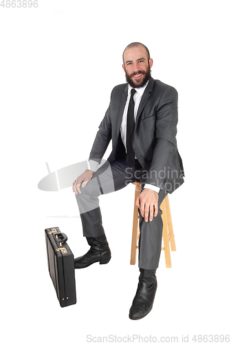 Image of Business man sitting with his and briefcase