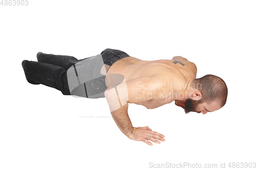 Image of Young man doing punch-ups on the floor