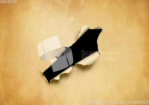 Image of Old torn parchment paper with black hole