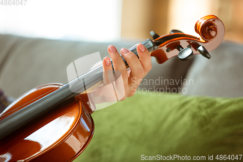 Image of Young woman studying at home during online courses or free information by herself, close up shoot of violin