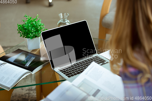 Image of Young woman studying at home during online courses or free information by herself, focus on laptop