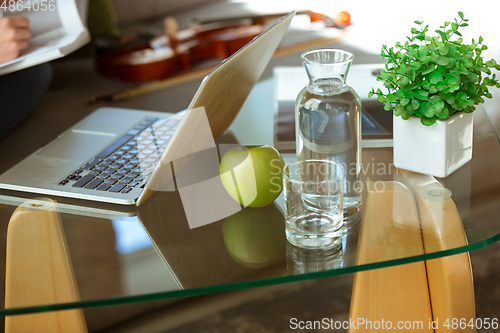 Image of Young woman studying at home during online courses or free information by herself, focus on table