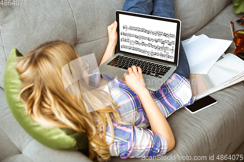 Image of Young woman studying at home during online courses or free information by herself