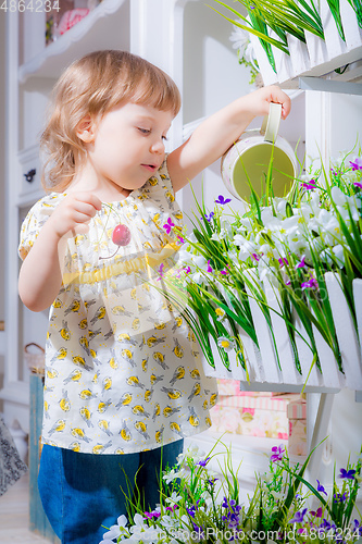 Image of little girl watering flowers