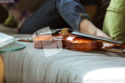 Image of Young woman studying at home during online courses or free information by herself, close up shoot of violin