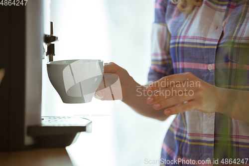 Image of Close up of female hands making coffee on coffee-machine at home or cafe