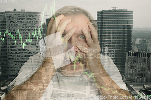 Image of Stressed senior man holding head with hands on abstract city background. Double exposure with graphs. Virus alert, coronavirus pandemic, crisis, unemployment
