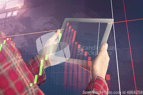 Image of Hands holding tablet showing graphs going down. Double exposure with graphs, digital. Virus alert, coronavirus pandemic, crisis, unemployment