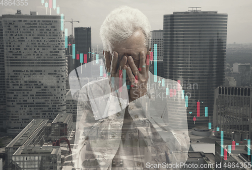 Image of Stressed senior man holding head with hands on abstract city background. Double exposure with graphs. Virus alert, coronavirus pandemic, crisis, unemployment