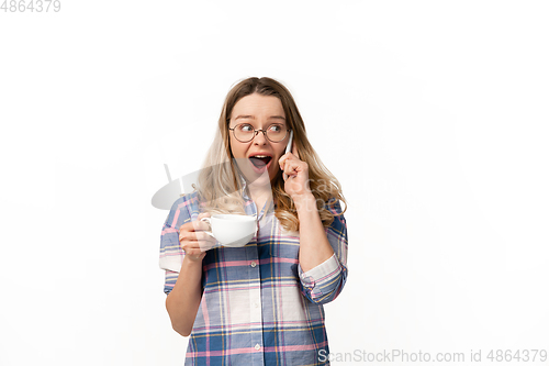 Image of Emotional caucasian woman using smartphone isolated on white studio background, technologies. Talking shocked