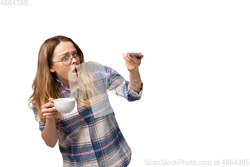 Image of Emotional caucasian woman using smartphone isolated on white studio background, technologies. Scared, shocked