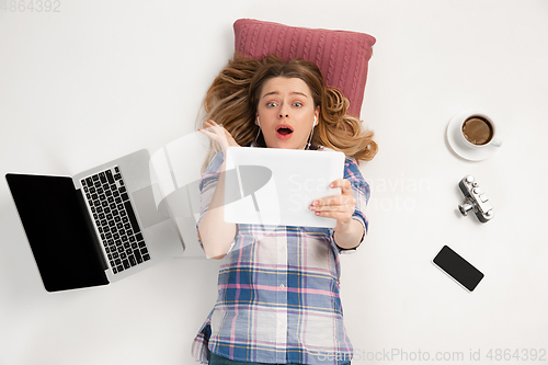 Image of Emotional caucasian woman using gadgets isolated on white studio background, technologies connecting people. Online shopping, selfie, gaming