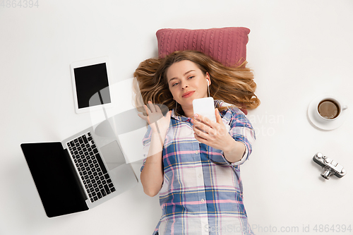 Image of Emotional caucasian woman using gadgets isolated on white studio background, technologies connecting people. Greeting