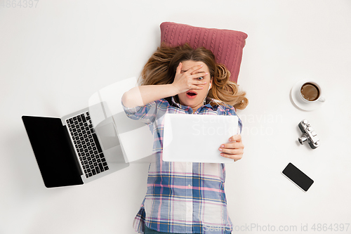 Image of Emotional caucasian woman using gadgets isolated on white studio background, technologies connecting people. Shocked, scared