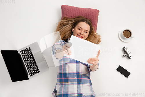 Image of Emotional caucasian woman using gadgets isolated on white studio background, technologies conncecting people. Online shopping, selfie, gaming